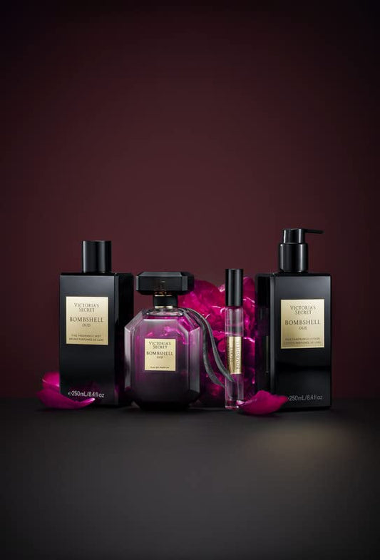 Collection of perfume bottles with pink flowers on a dark background