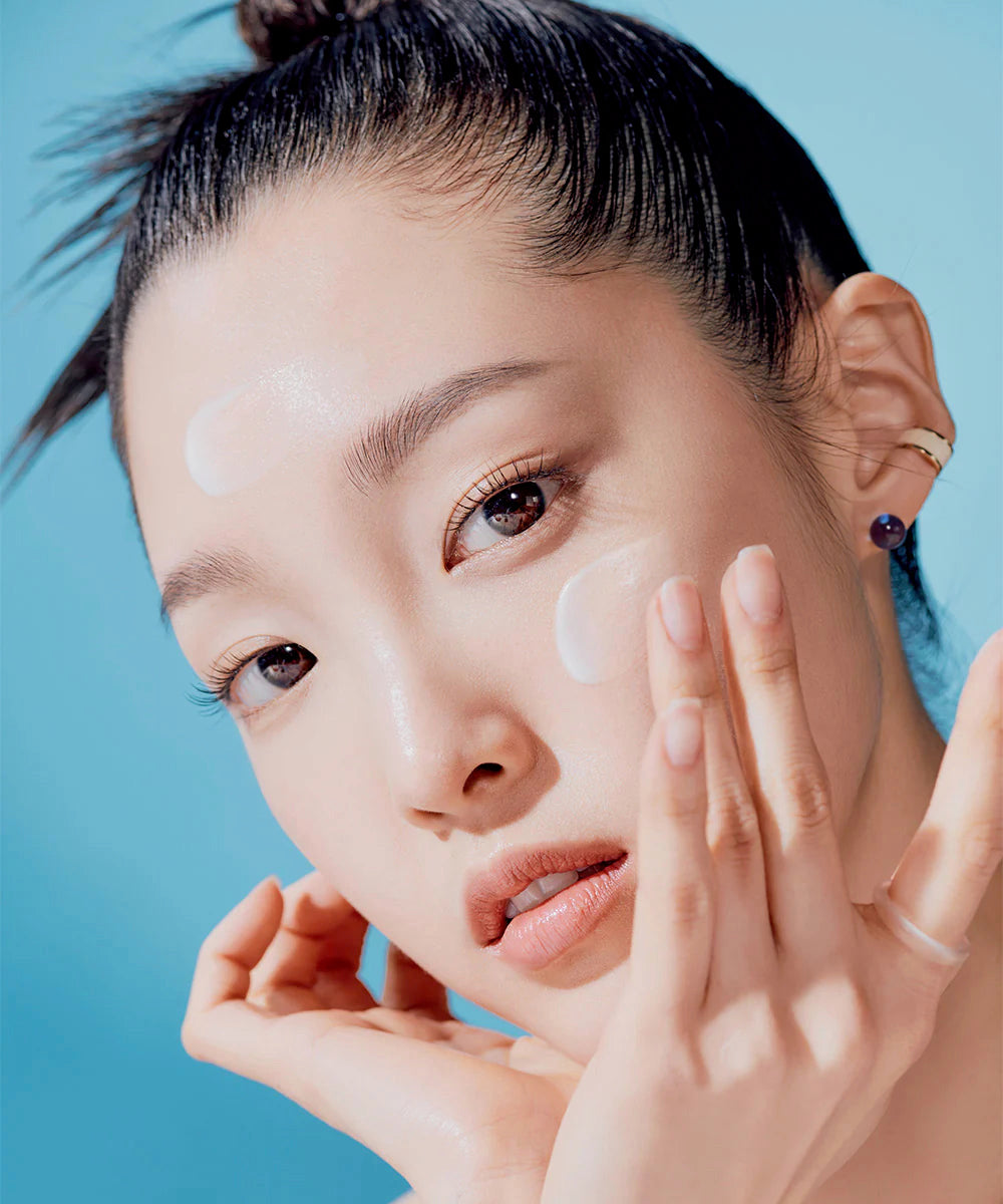 Close-up of a person with their hand near their face against a blue background