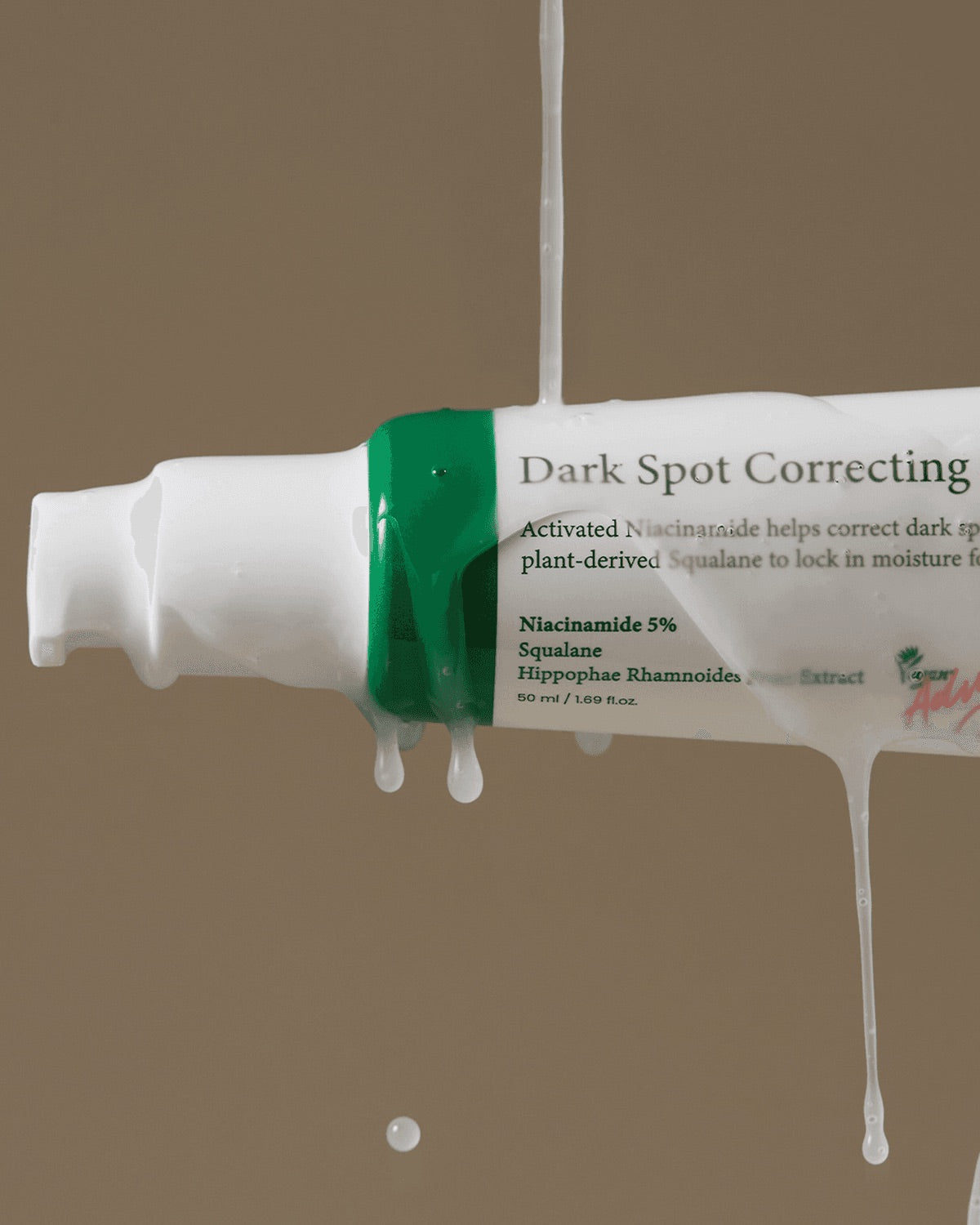 Tube of dark spot correcting cream with visible text on a beige background