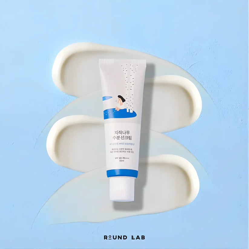 Tube of cream on a white dish with a blue background, featuring the brand 'ROUND LAB'.