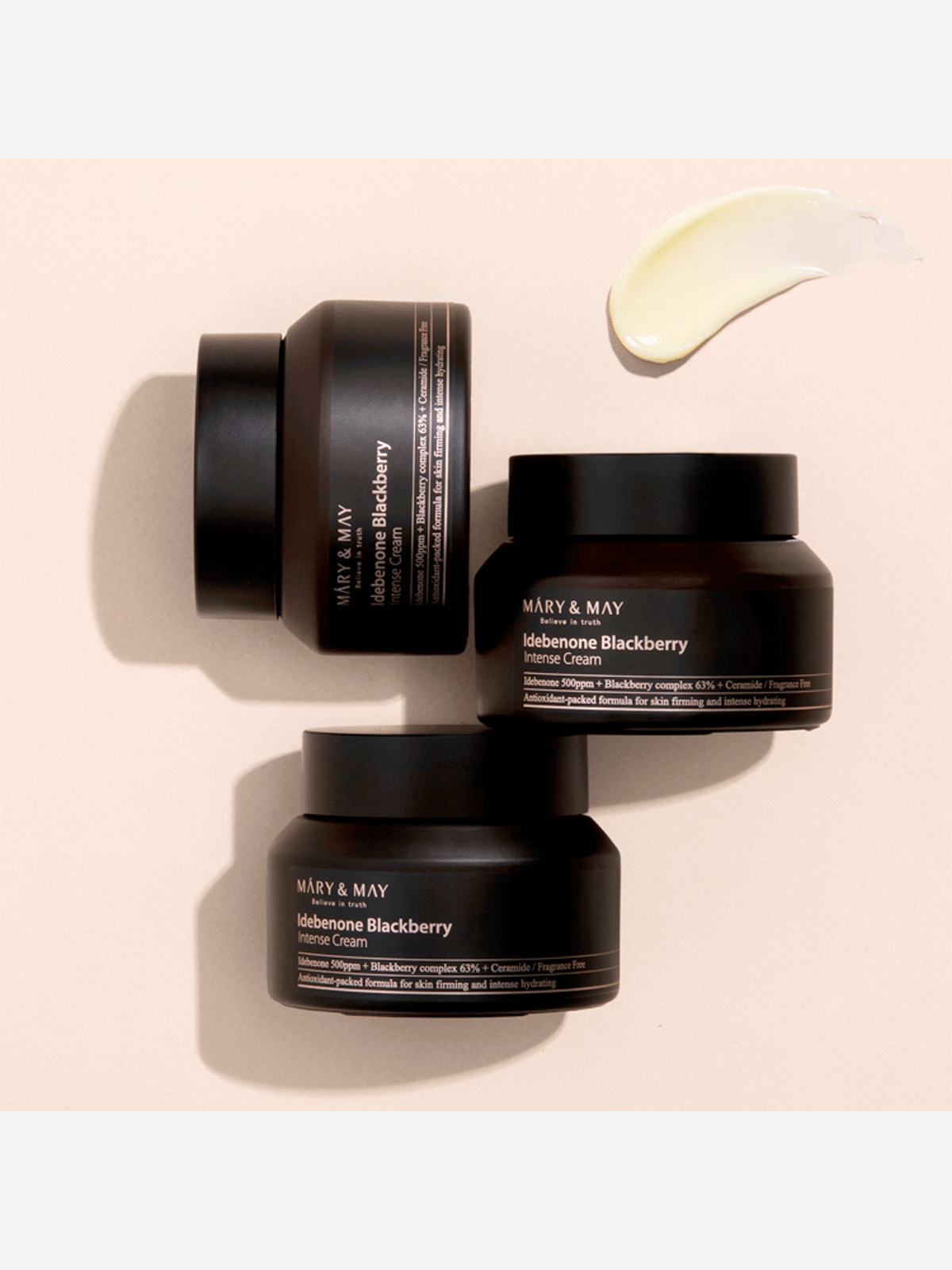 Three black cosmetic jars with 'Mary & May' branding on a beige background