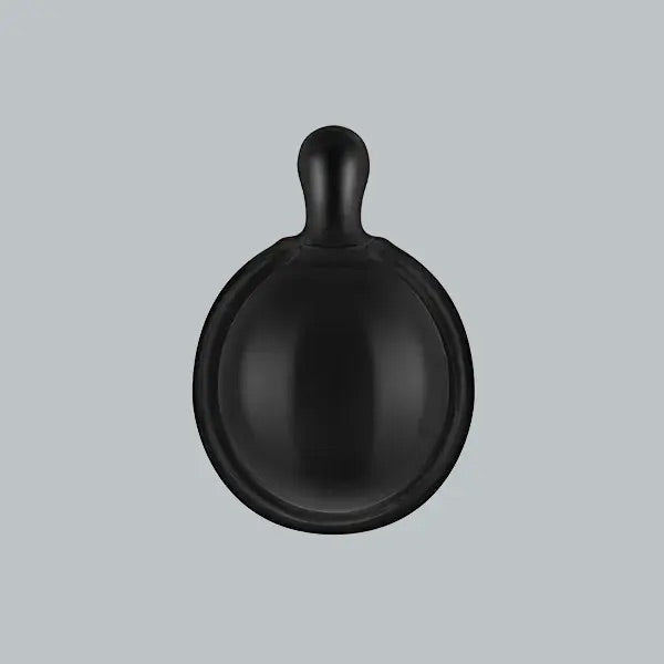 Black ceramic bowl with handle on a light gray background