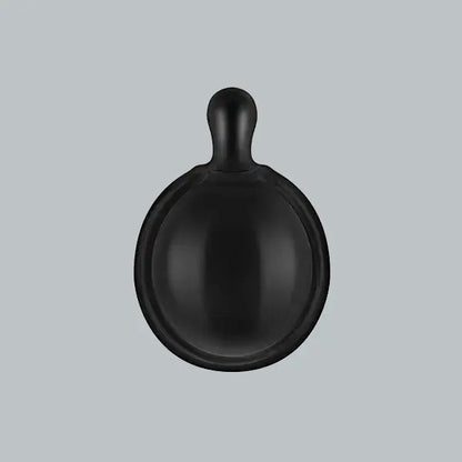Black ceramic bowl with handle on a light gray background