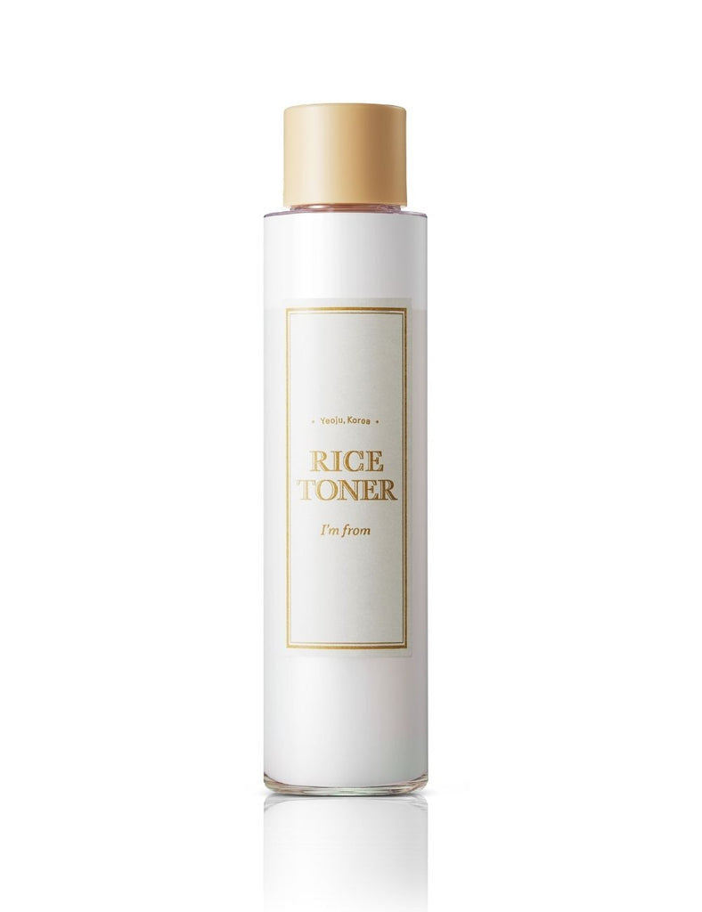 White bottle of rice toner with gold cap on a white background