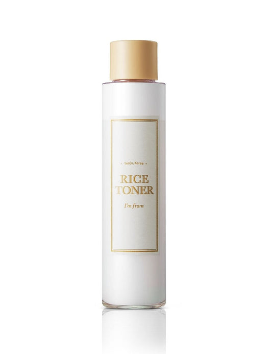White bottle of rice toner with gold cap on a white background