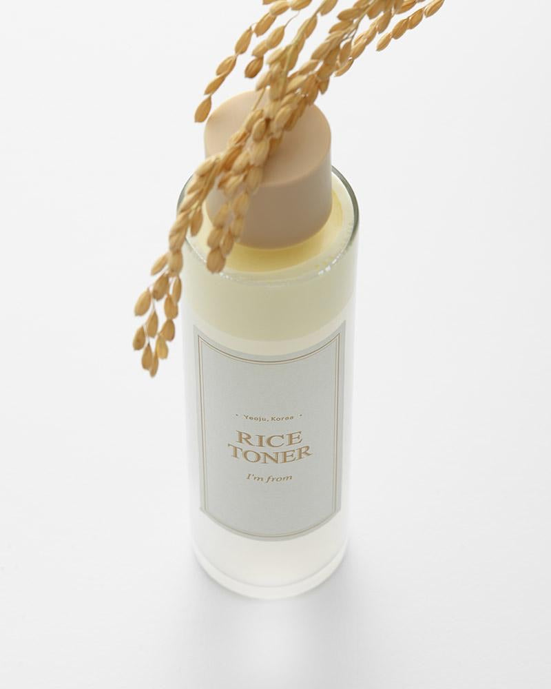 Bottle of rice toner with a beige cap on a white background
