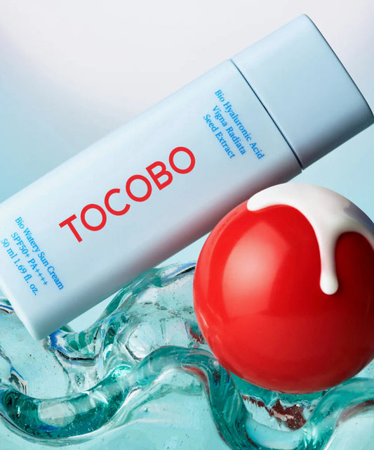 Tocobo skincare product with a red ball and white cream on a light blue background