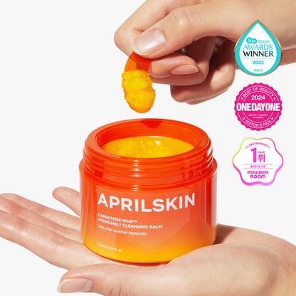 Orange jar of Aprilskin cleansing balm with a hand holding a yellow sponge, on a white background.