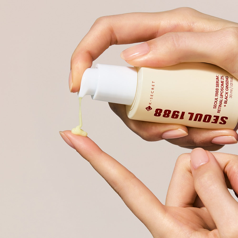 Hand holding a bottle of Seoul 1988 skincare serum with a beige background