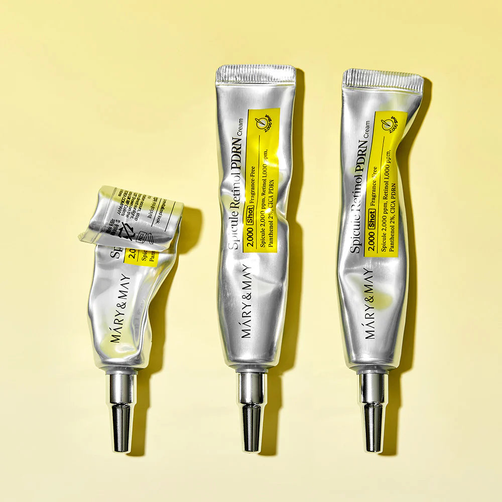 Three tubes of Mary & May eye cream on a yellow background