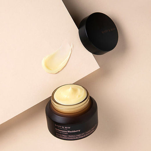 Black jar of cream with a visible brand name on a beige background
