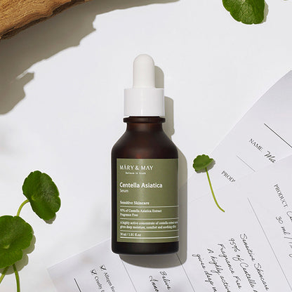 Skincare serum bottle with dropper labeled 'Mary & May' on a light background with green leaves.