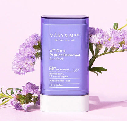 Vegan Peptide Bakuchiol Sun Stick by Máry & May with purple flowers on a light pink background